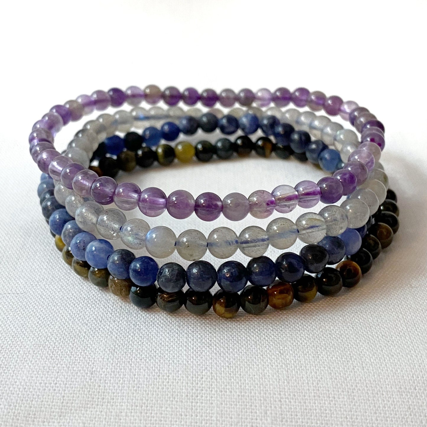 Image of a promotional poster for the "Sagittarius Beaded Bracelet Set." It features five beaded gemstone bracelets made of Amethyst, Blue Labradorite, Sodalite, and Blue Tiger Eye. Text describes Sagittarius traits, dates (November 22 - December 21), and showcases Reiki Infused Bracelets radiating Sagittarius energy.