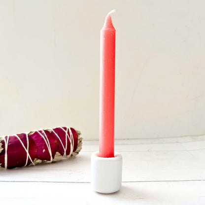 A bundle of four 5" Pink Chime Candles, tied together with a black string, placed on a white wooden surface. These ritual candles are evenly aligned, showing their pointed tips clearly against the light background.